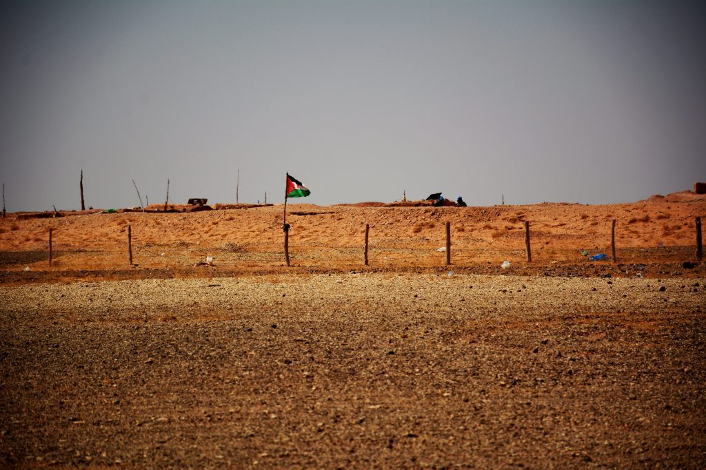 Den västsahariska flaggan vid ett staket i saharaöknen efter bruten vapenvila