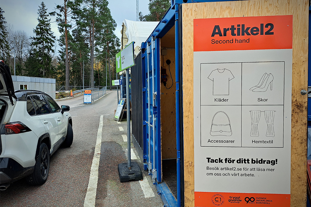 Skylt med Artikel2 logotyp på Boo Kretsloppscentral i Nacka, vid insamlingen av kläder och prylar.