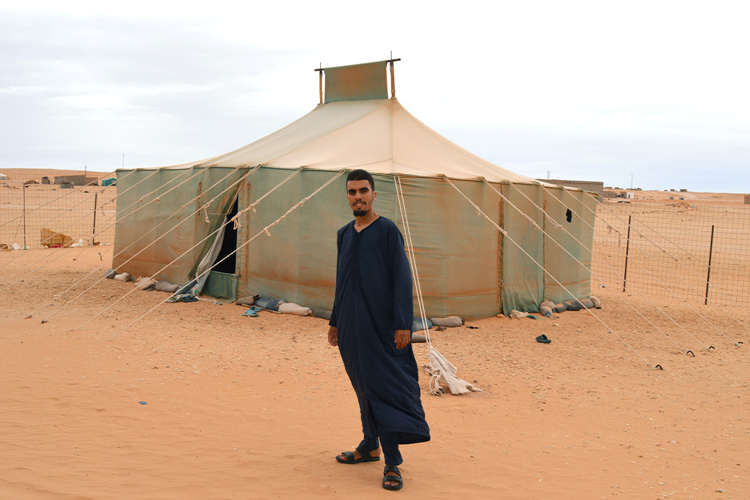 Abid står framför ett tält i de västsahariska flyktinglägren. Han tittar rakt in i kameran. 