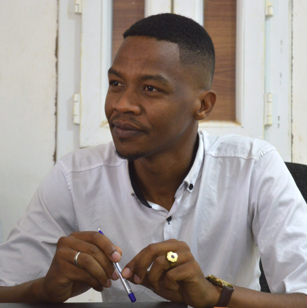 Asalik_50kampanj Asalik sitter på ett kontor i de västsahariska flyktinglägren. Han håller i en penna.