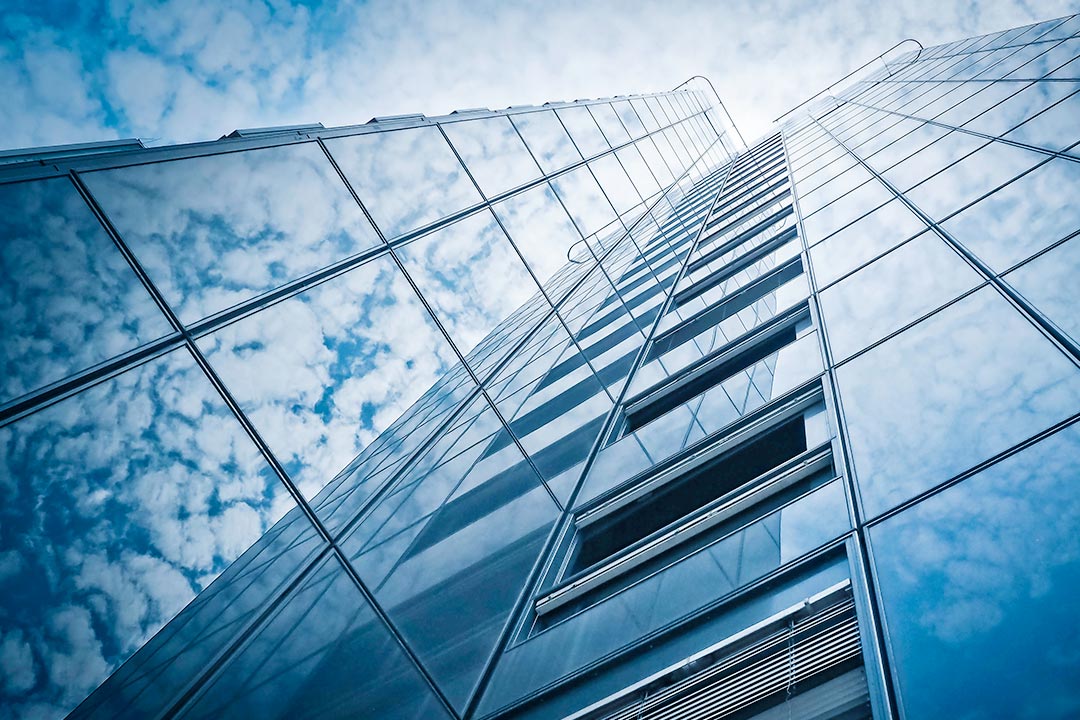 Skyskrapa med moln som speglas