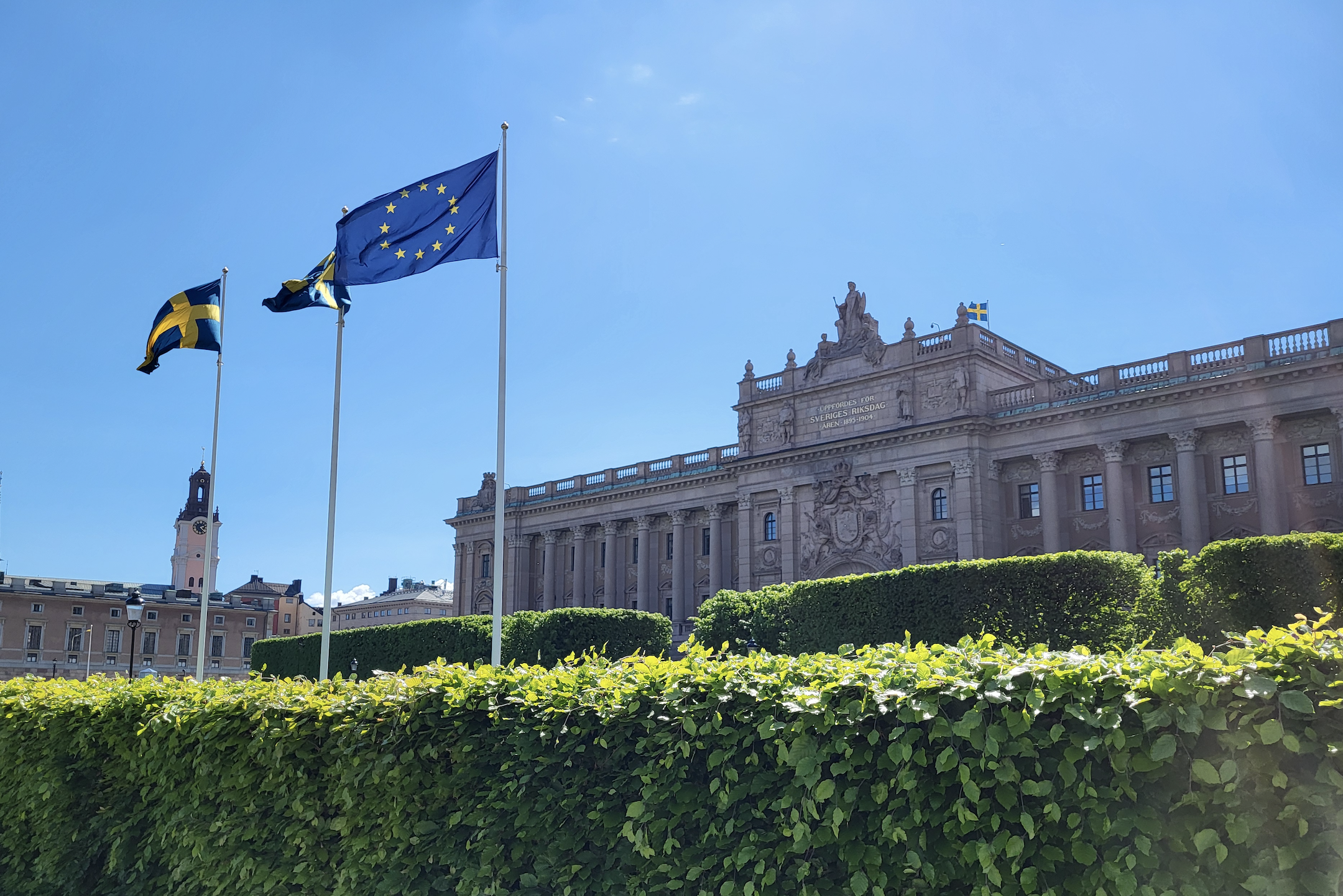 Riksdagsbyggnaden. Sveriges och EU:s flaggor framför byggnaden.